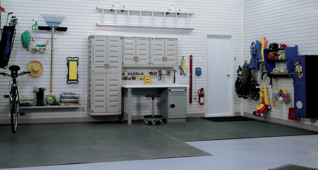 Garage space arranged with wall mounted cabinets.